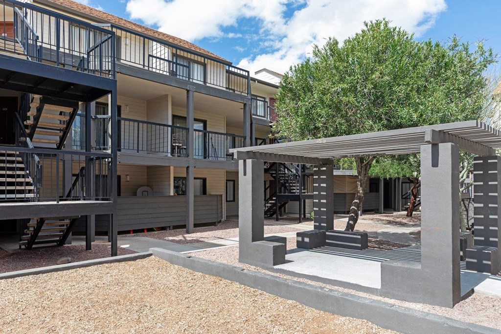 A modern building with a balcony and a tree in the background.