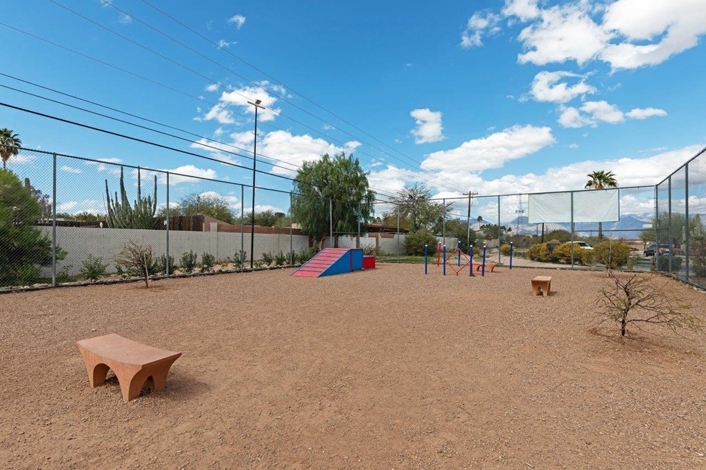 A playground with a red bench and a slide.