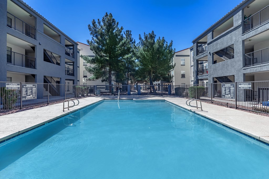 A swimming pool in front of apartment buildings.
