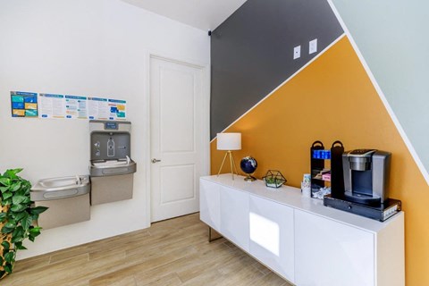 A white and orange kitchen with a coffee maker on the counter.