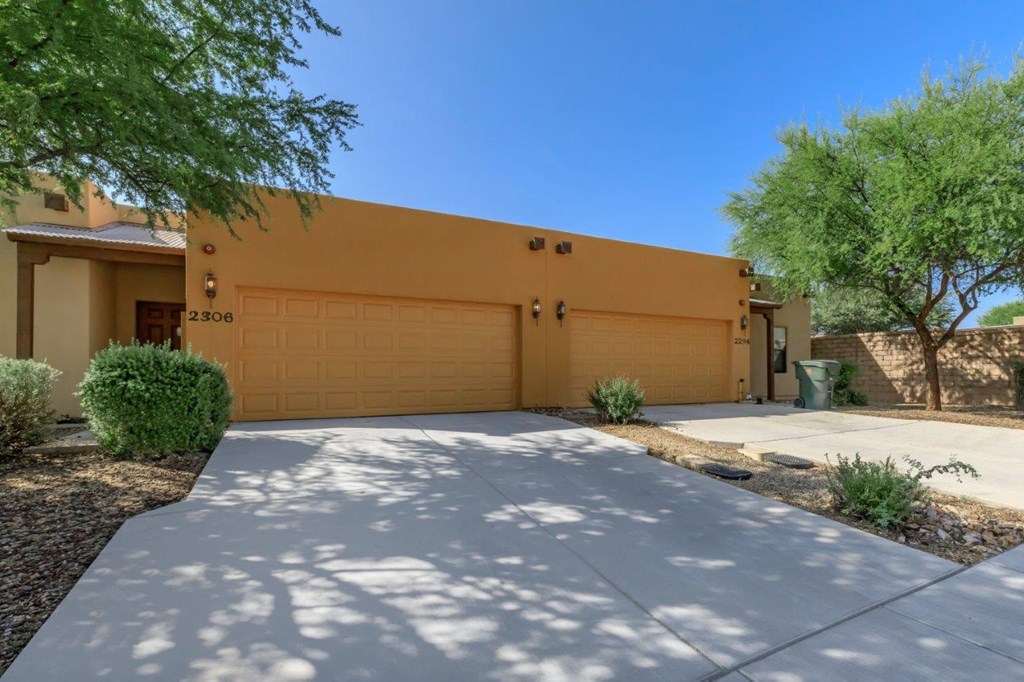 A house with a yellow garage door and a driveway leading to it.