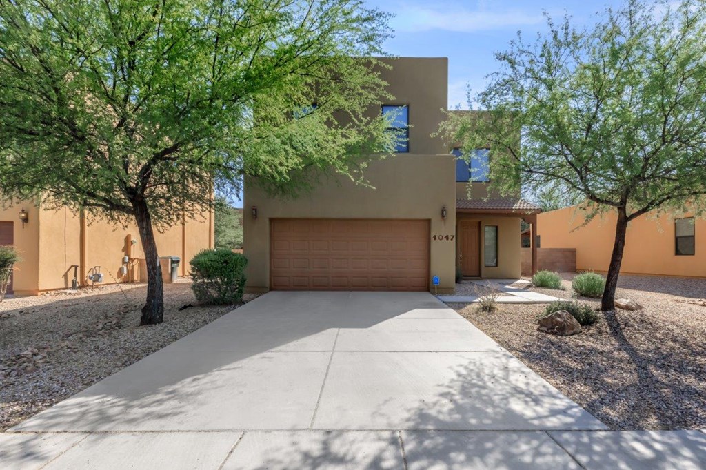 A modern house with a brown garage door and a driveway.