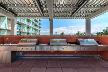 A row of grills are on a patio.