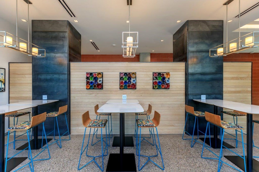 A modern dining area with a white table and blue chairs.