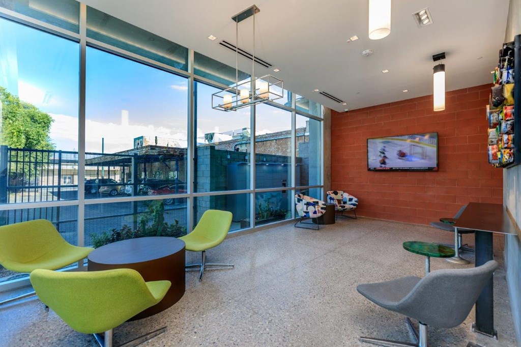 A room with a table and chairs and a television on the wall.