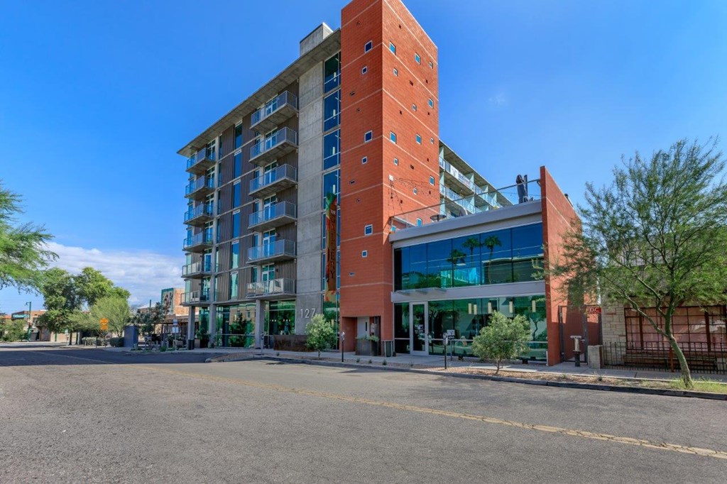 A large red building with a glass entrance and balconies.