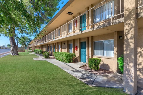 A row of apartment buildings with blue doors and windows.