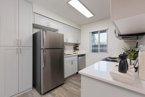 a kitchen with white cabinets and a stainless steel refrigerator