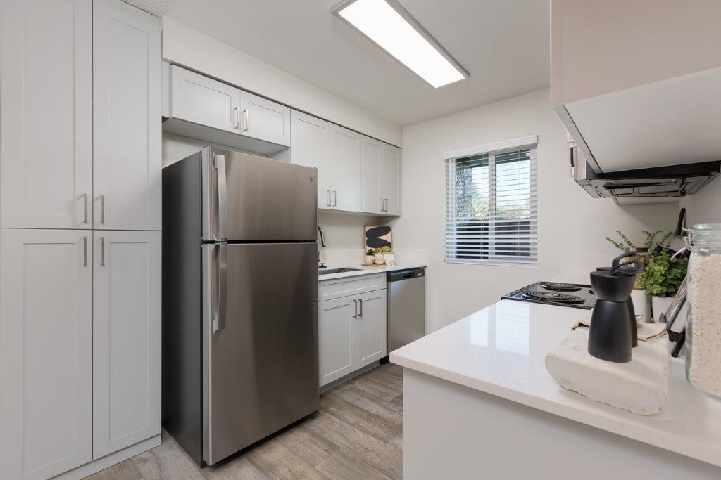 a kitchen with white cabinets and a stainless steel refrigerator
