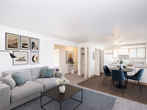A living room with a grey couch, a coffee table, and a dining table with chairs.