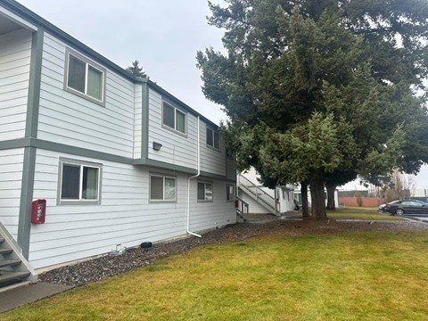 A white building with a red fire hydrant on the side.