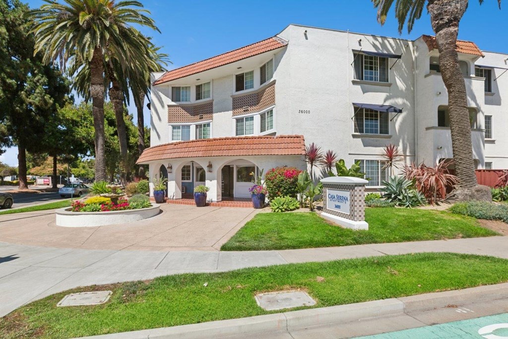 A white building with a red roof and a sign that says