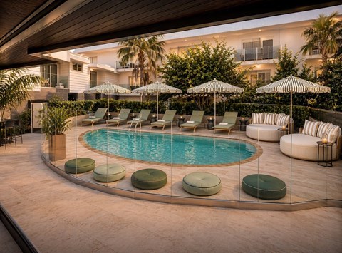A pool surrounded by lounge chairs and umbrellas.