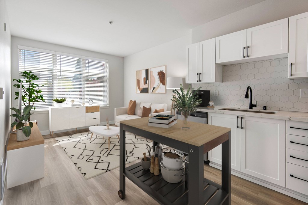 A kitchen with white cabinets and a wooden island.