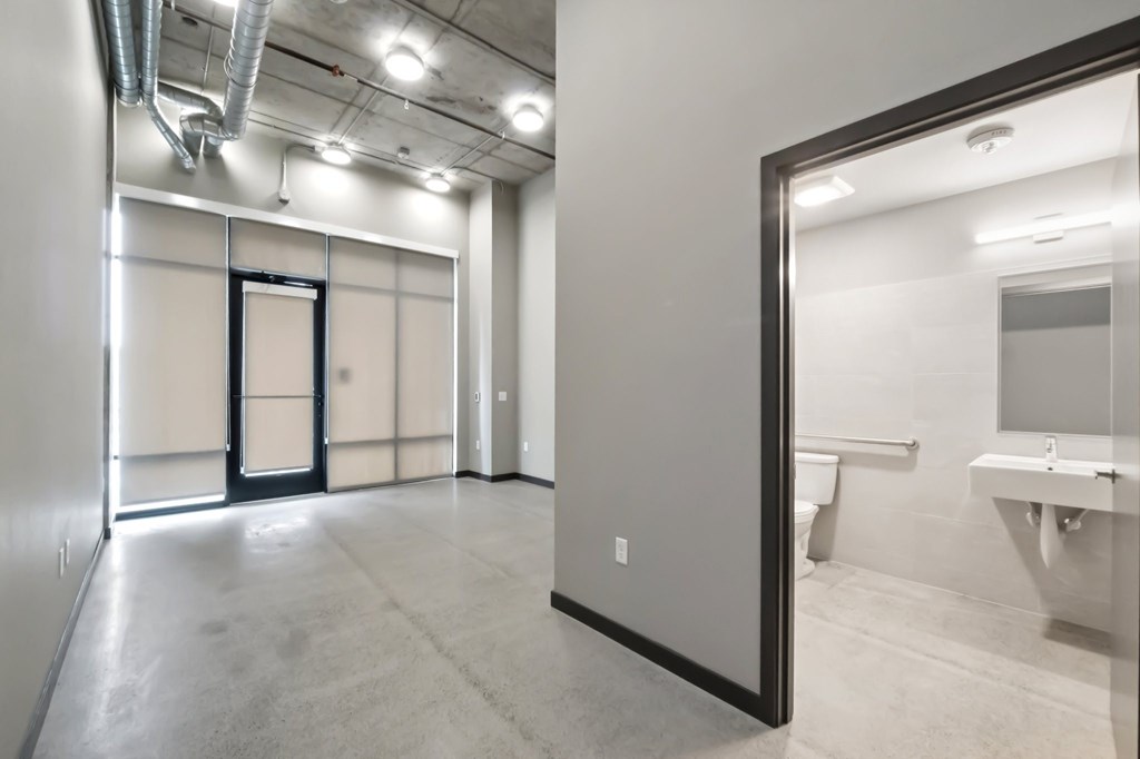 A bathroom with a toilet, sink, and mirror.