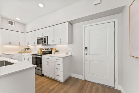 a white kitchen with white cabinets and a black stove and