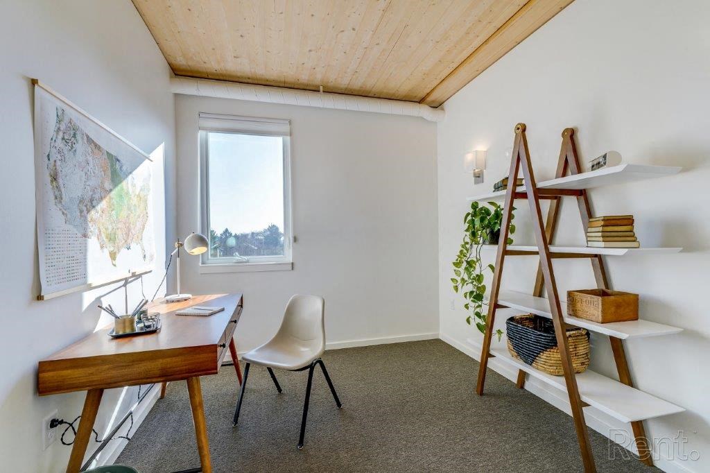 a home office with a ladder and a map on the wall