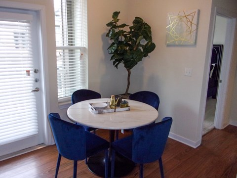 A dining room with a round table and blue chairs.