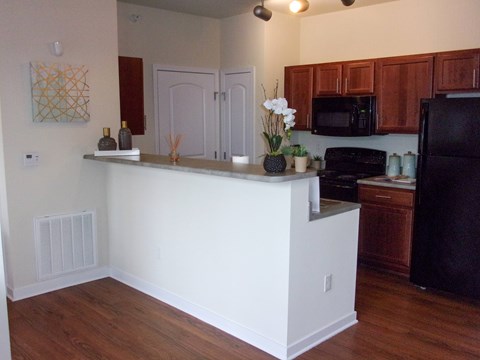 A kitchen with a white island and wooden cabinets.