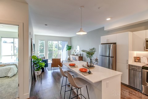 A kitchen with a white counter and a refrigerator.