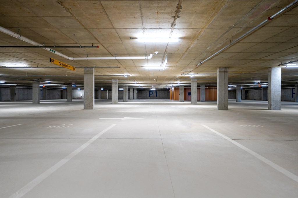 Empty parking garage with concrete pillars and ceiling.