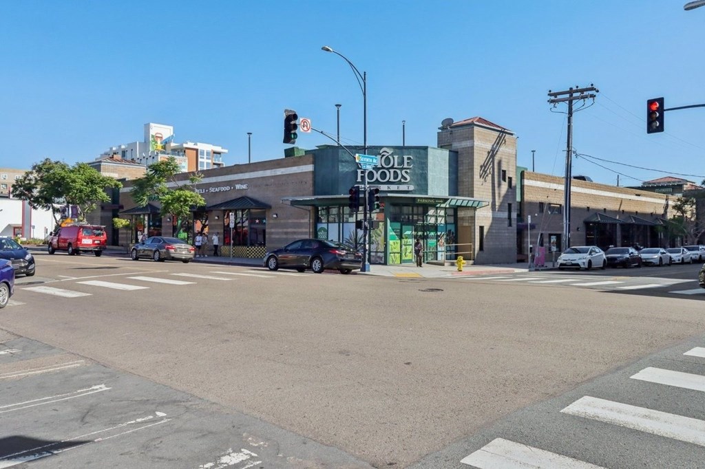 A street view with a traffic light showing red and a storefront with a green awning.