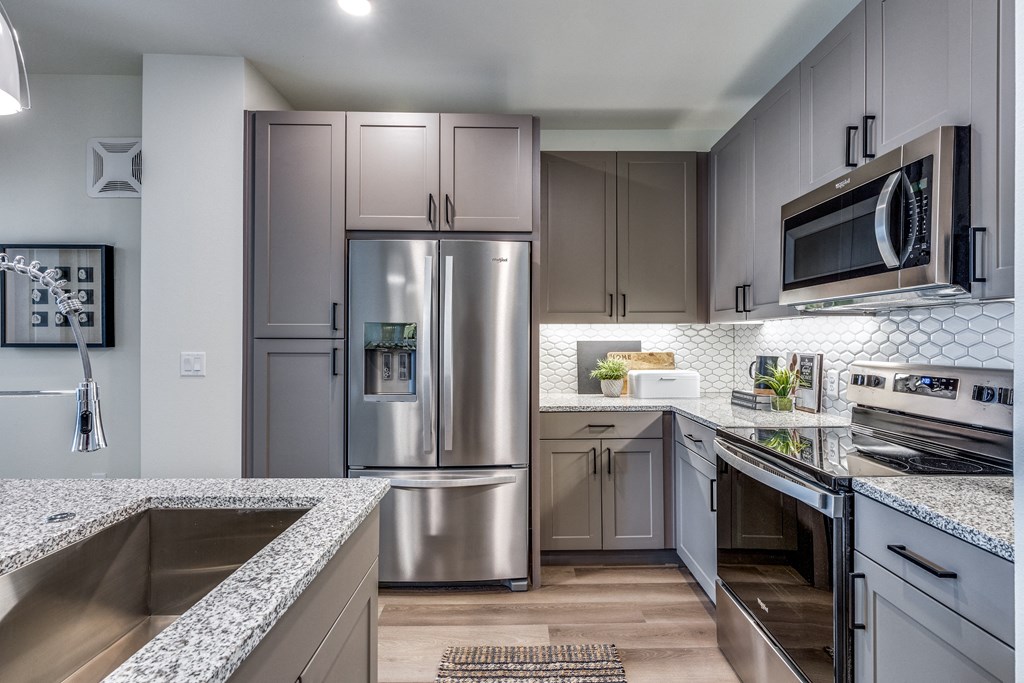 an open kitchen with granite counter tops and stainless steel appliances