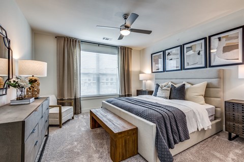 a bedroom with a large bed and a ceiling fan
