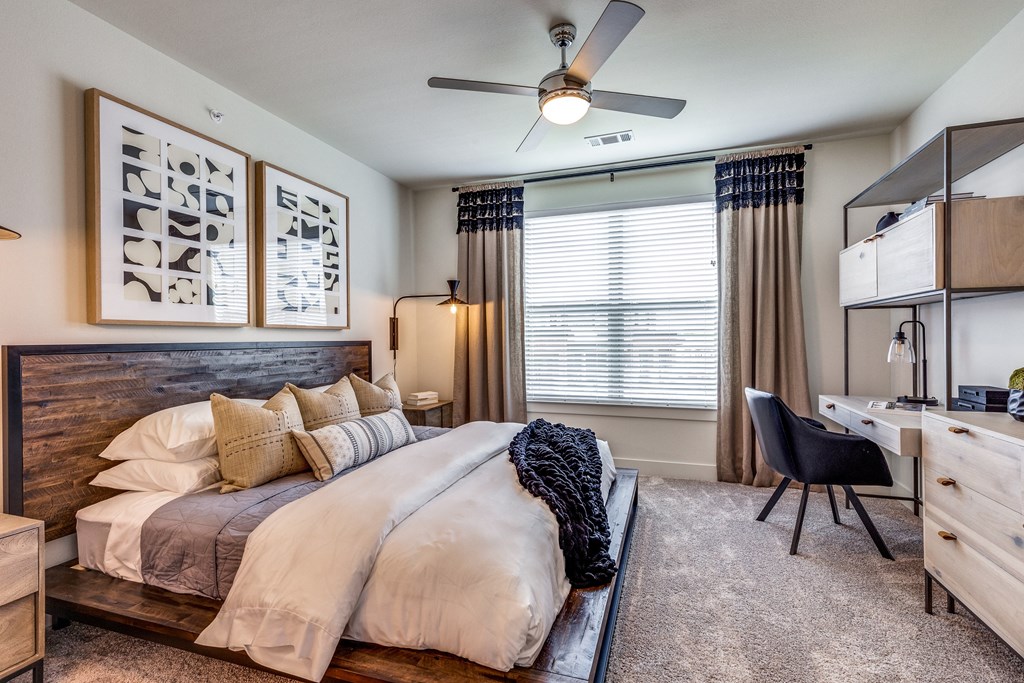 a bedroom with a large bed and a ceiling fan