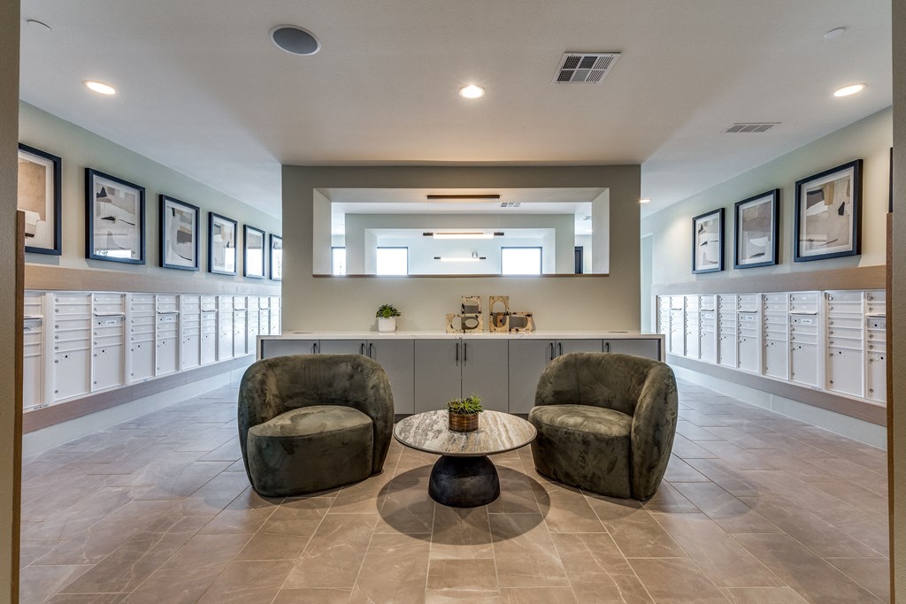 a lobby with two chairs and a counter with mailboxes