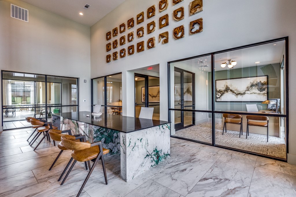 an open kitchen and dining room with a marble counter top and chairs