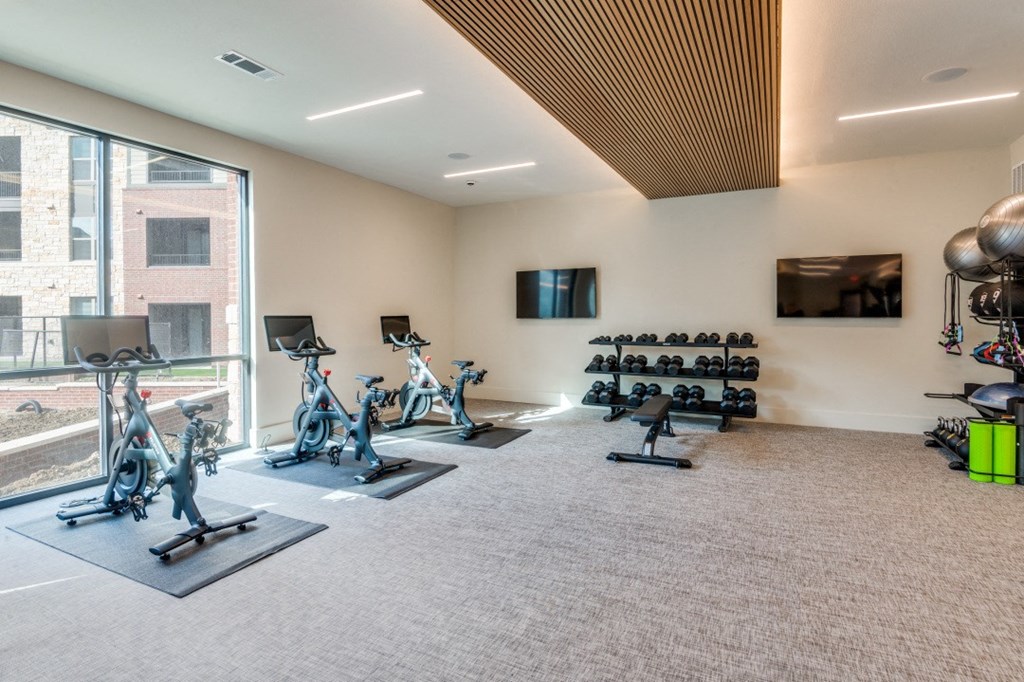 a gym with exercise equipment and a large window