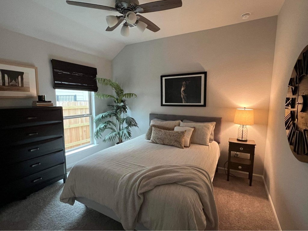 a bedroom with a large bed and a ceiling fan