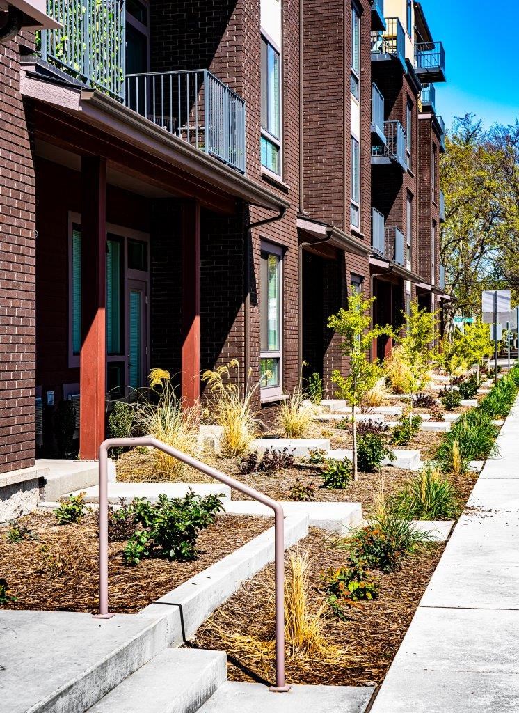 a garden in front of a brick building