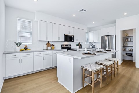 A modern kitchen with white cabinets and a central island.