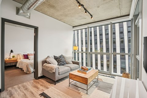 A living room with a grey couch and a wooden coffee table.