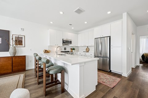 A kitchen with white cabinets and a white island.