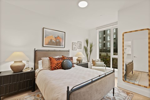 A bedroom with a large bed and a painting of two horses on the wall.