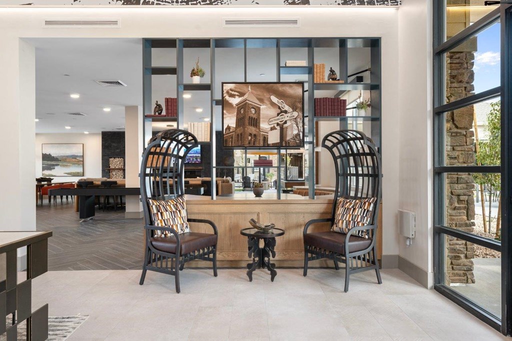 the lobby or reception area of a hotel with a bar and chairs