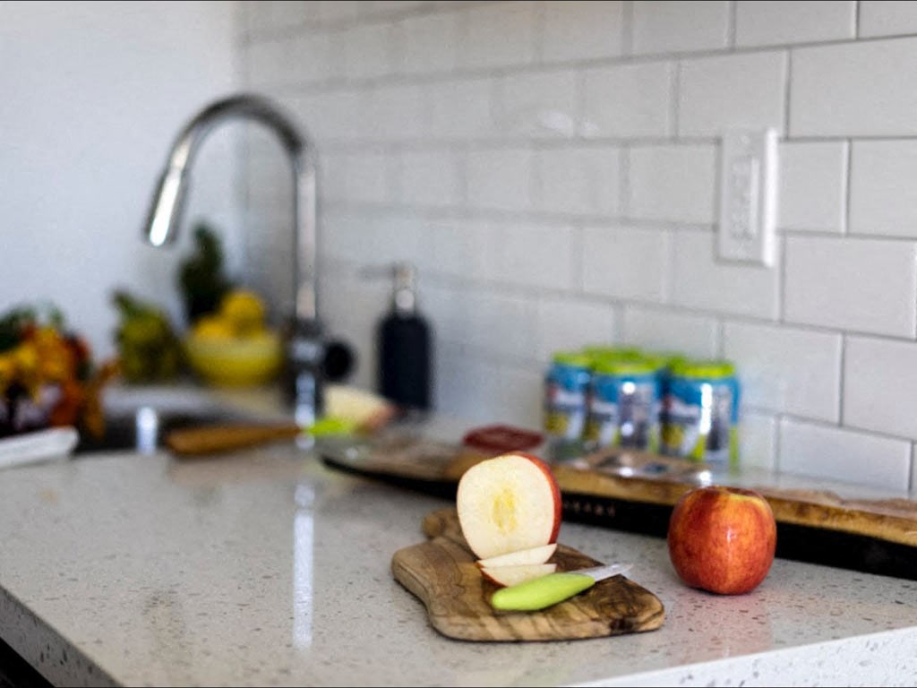 a kitchen counter with an apple on a cutting board
