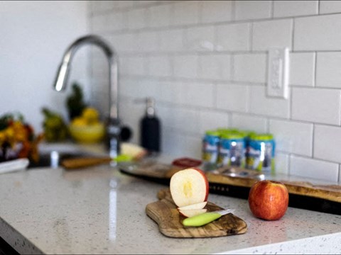 a kitchen counter with an apple on a cutting board