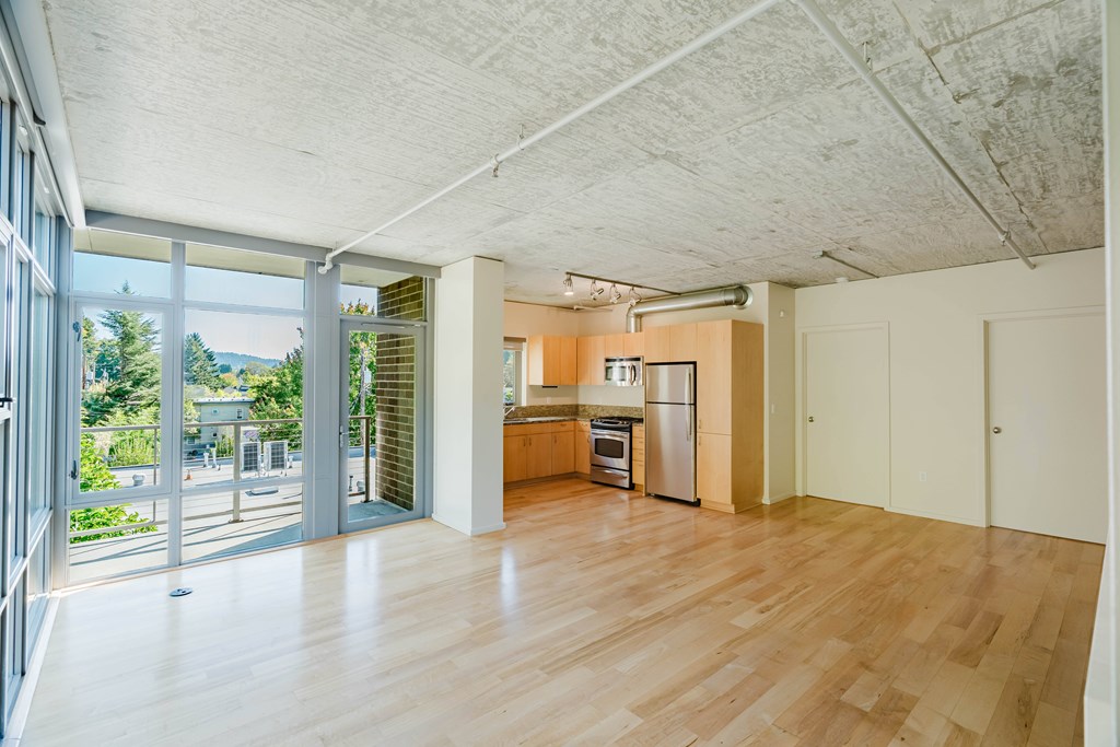 A kitchen with a refrigerator, oven, and sink is visible from the living room.