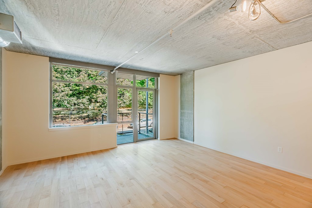 A room with a large window and sliding glass doors.