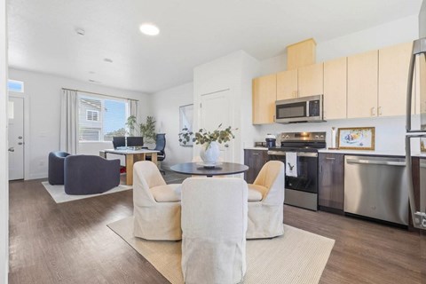 A modern kitchen with a dining table and chairs in the middle of the room.