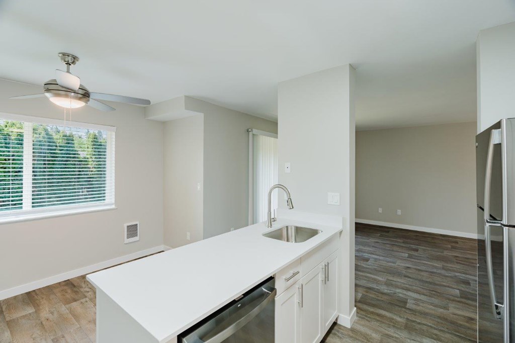 A kitchen with a white countertop and a refrigerator.