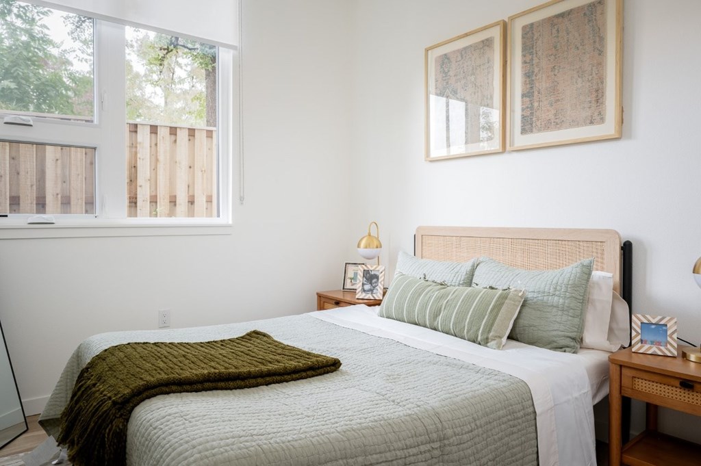 The Wes Gresham Oregon Apartments bedroom with a bed and window