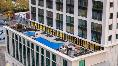 A large white building with a pool in front.