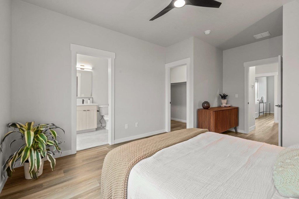 A bedroom with a large bed and a ceiling fan.
