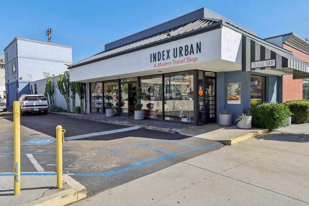 A modern travel shop named Index Urban is located in a parking lot.