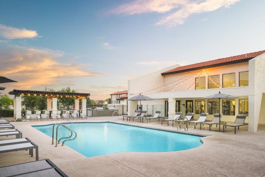 a swimming pool in front of a hotel with a building